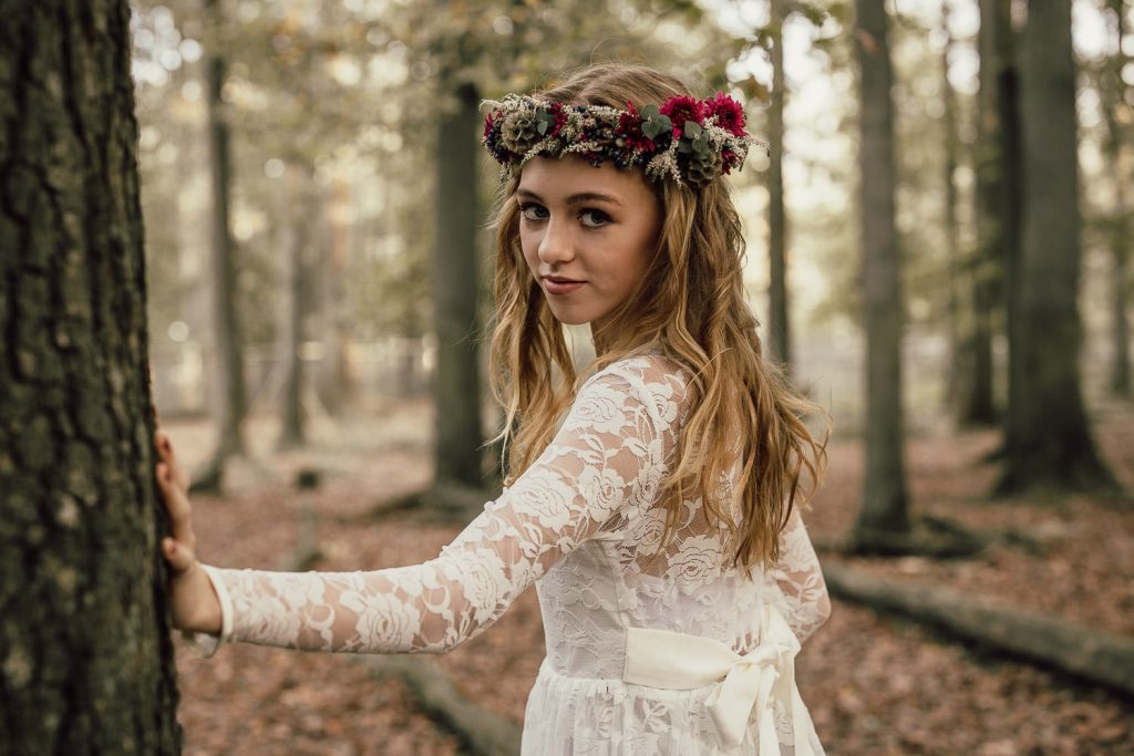 Junge Dame mit Blumenkranz im Wald